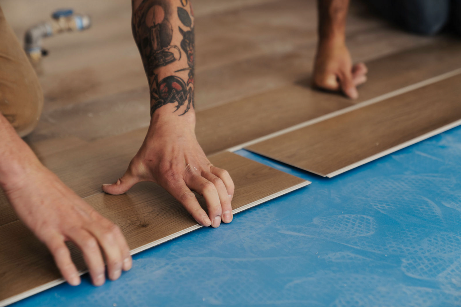 A photo of Hewn Stoneform Select Luxury Plank Flooring being installed in a home.