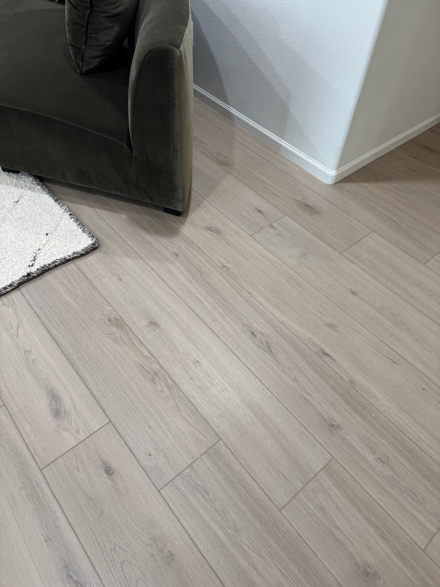 Living Room Photo of the color Meadow from the DeBoer Elite Stoneform Luxury Vinyl Plank Flooring Collection with a chair and rug