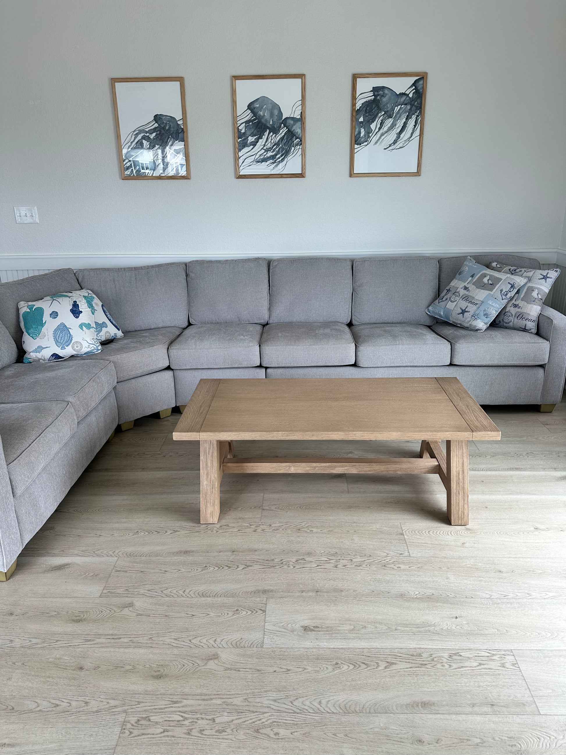 Photo of Elk Angela Rose Elite Stoneform Plank Flooring in a Living Room with an L-Shaped Couch