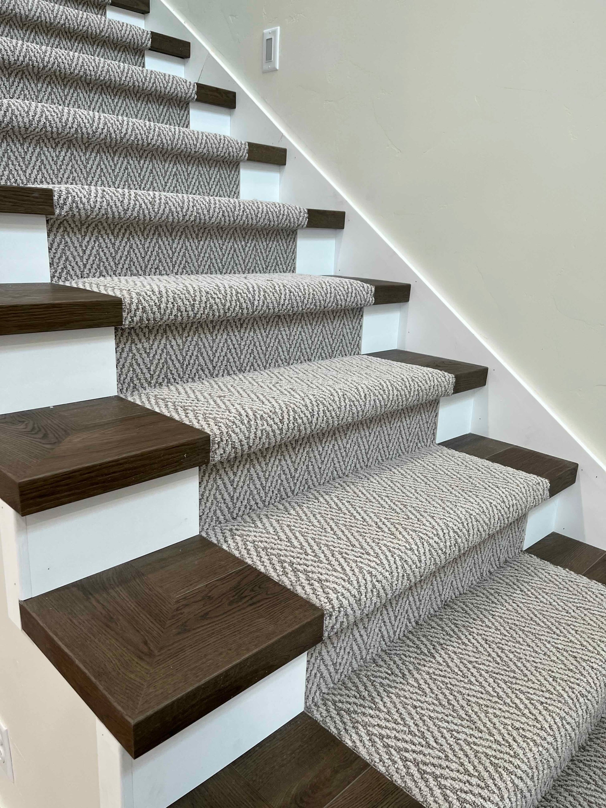 Photo of a staircase with a carpet runner and Hewn Stoneform Square Stair Nose Transitions with Finished Edge Technology