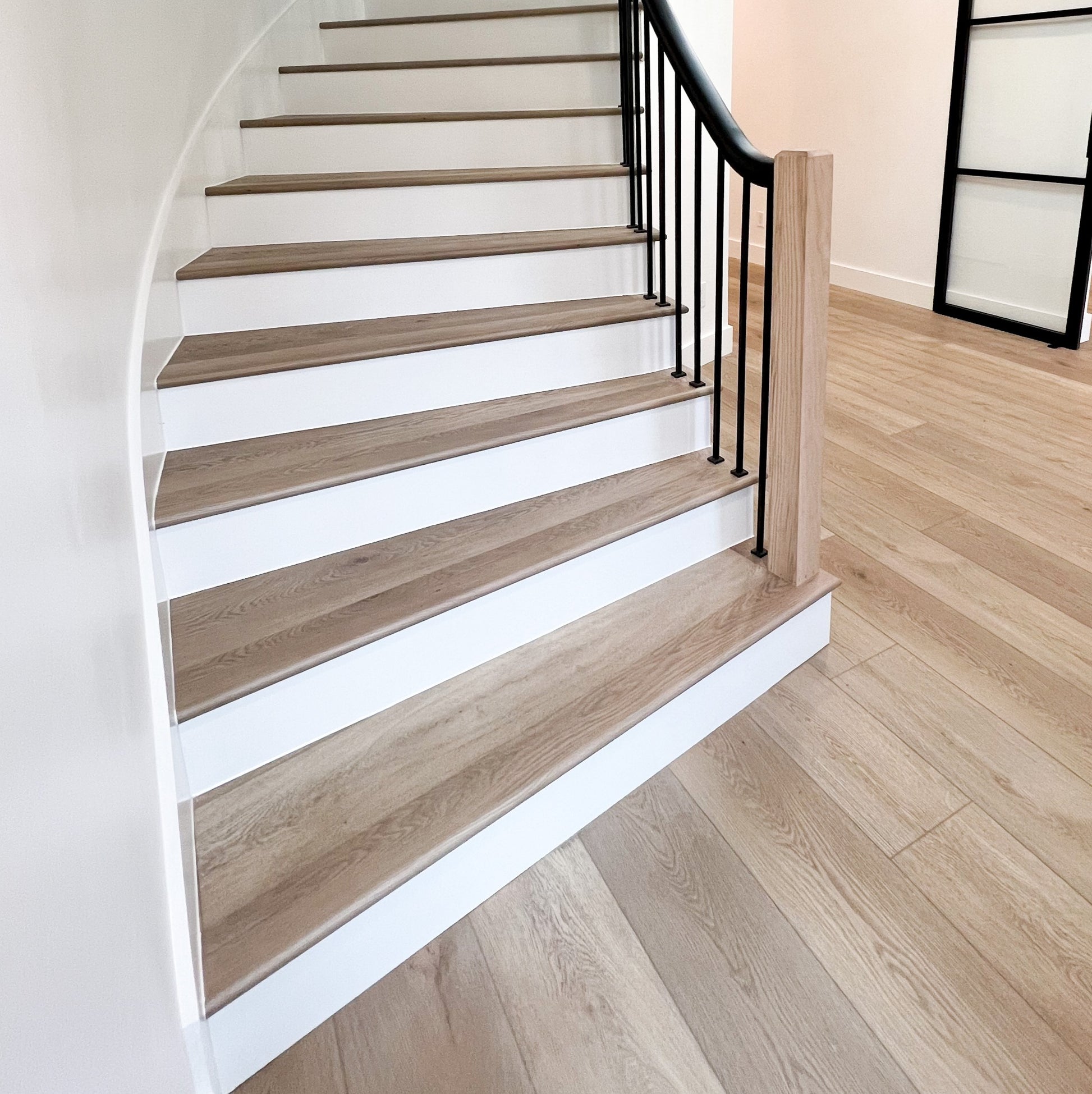 Photo of a curved staircase with Hewn's rounded stair nose in Rustic Stoneform Flooring