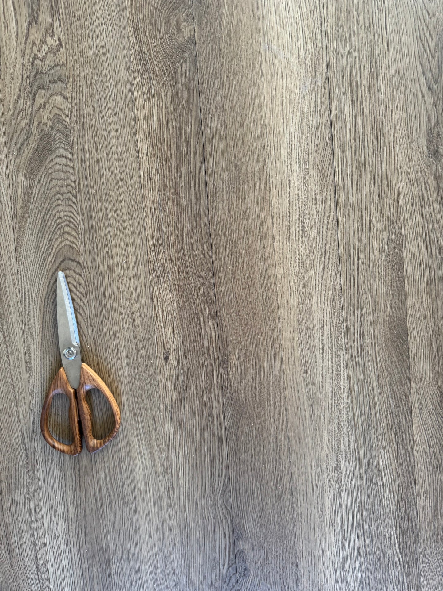 A closeup photo of scissors on top of cut pieces of Hewn's Galey Alix Elite Stoneform for Walls and Ceilings in the color Archer.